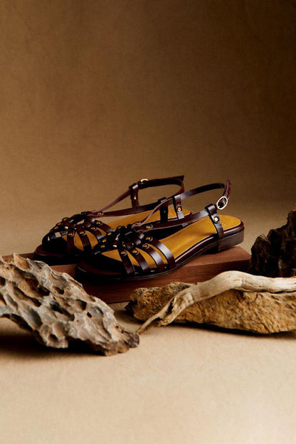Sandalias tachuelas metálicas y aberturas en marrón oscuro